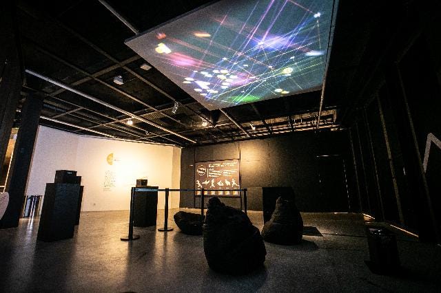 Pessoas interagindo com o projeto DATASKY na exposição Data Corpus